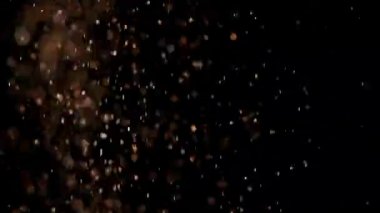 Siyah arka plan üzerinde patlayan gerçekçi Glitter.
