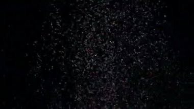 Siyah arka plan üzerinde patlayan gerçekçi Glitter.