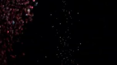 Siyah arka plan üzerinde patlayan gerçekçi Glitter.