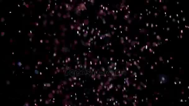 Paillettes réalistes explosant sur fond noir .