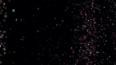 Siyah arka plan üzerinde patlayan gerçekçi Glitter.