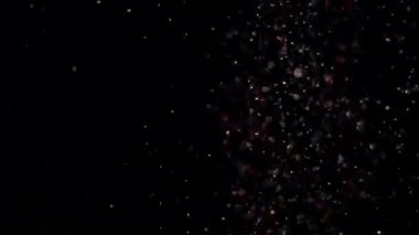 Siyah arka plan üzerinde patlayan gerçekçi Glitter.