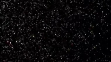 Siyah arka plan üzerinde patlayan gerçekçi Glitter.