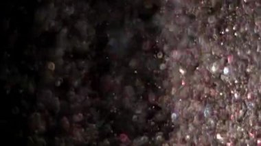 Siyah arka plan üzerinde patlayan gerçekçi Glitter.