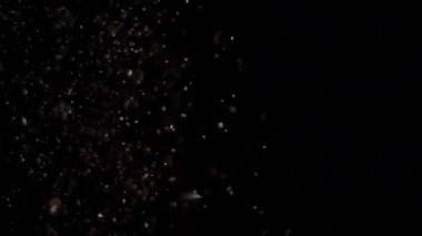 Siyah arka plan üzerinde patlayan gerçekçi Glitter.