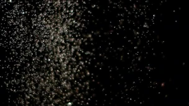 Paillettes réalistes explosant sur fond noir .