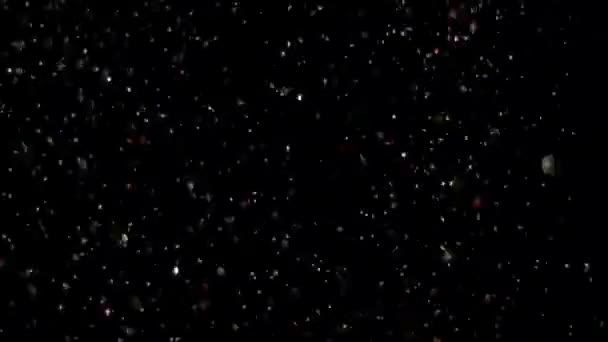 Paillettes réalistes explosant sur fond noir .