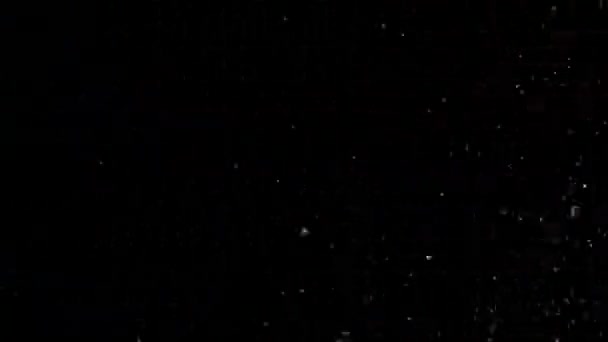 Paillettes réalistes explosant sur fond noir .