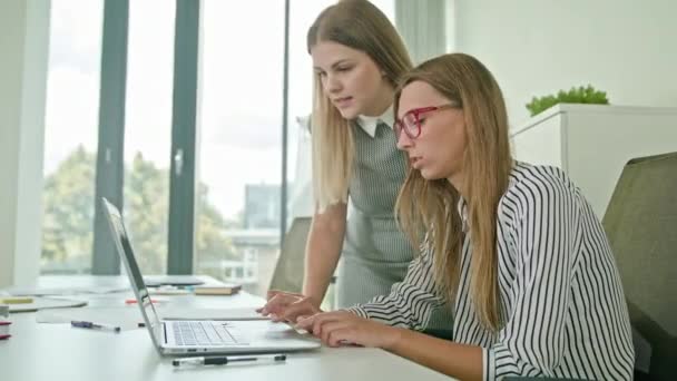 Dos mujeres discutiendo ideas usando el ordenador portátil — Vídeo de stock