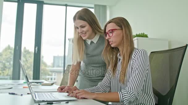 Дві жінки обговорюють ідеї використовуючи ноутбук — стокове відео