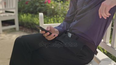 Genç adam parkta bir telefon kullanma