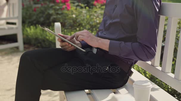 Joven en el parque usando una tableta — Vídeos de Stock