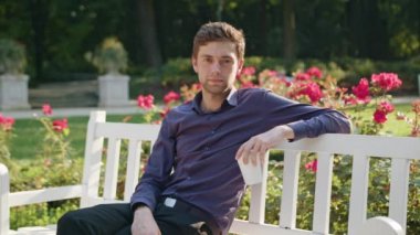 Genç adam parkta bir kahve içer