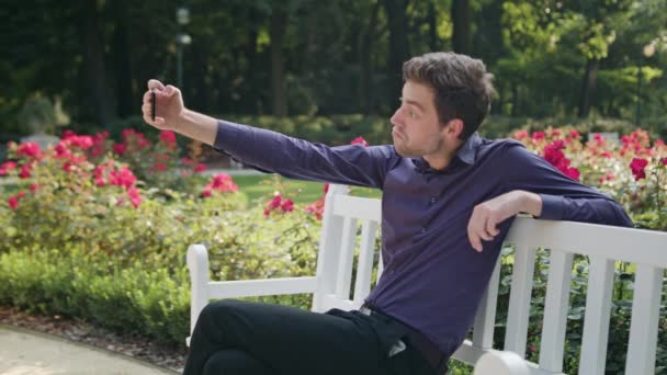 Joven en el parque haciendo un selfie — Vídeo de stock