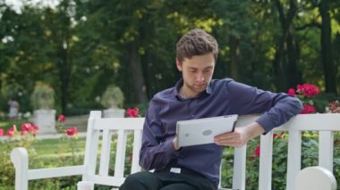 Genç adam parkta Tablet kullanma