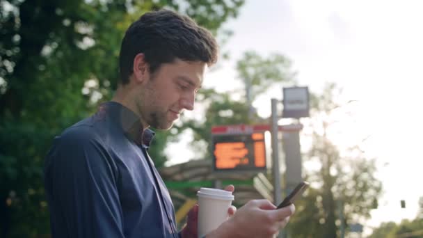 Joven en el parque usando un teléfono — Vídeo de stock