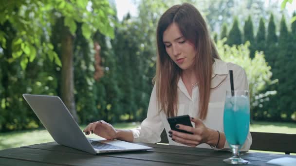 Femme d'affaires utilisant un ordinateur portable et un téléphone — Video