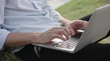 genç bir adam bir dizüstü bilgisayar açık havada kullanma