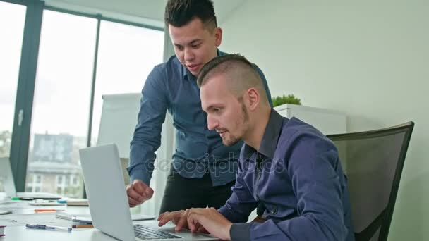 Dos hombres discutiendo ideas usando el ordenador portátil — Vídeo de stock