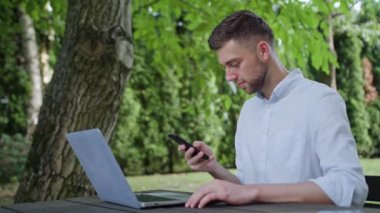 Parkta bir telefonu kullanarak bir genç adam