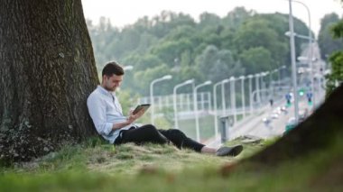 Genç bir adam açık havada bir Tablet kullanma