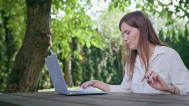 İş kadını parkta bir dizüstü bilgisayar kullanarak