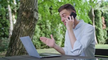 Parkta telefonda konuşan bir genç adam