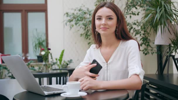 Schöne Mädchen mit einem Mobiltelefon im Zimmer — Stockvideo