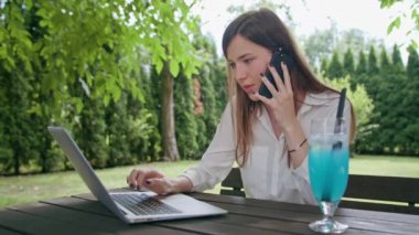 İş kadını bir dizüstü bilgisayar ve bir telefon kullanma