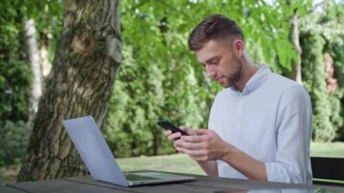 Parkta bir telefonu kullanarak bir genç adam