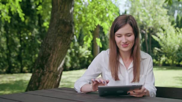 Young Lady gebruiken een ipad in het Park — Stockvideo