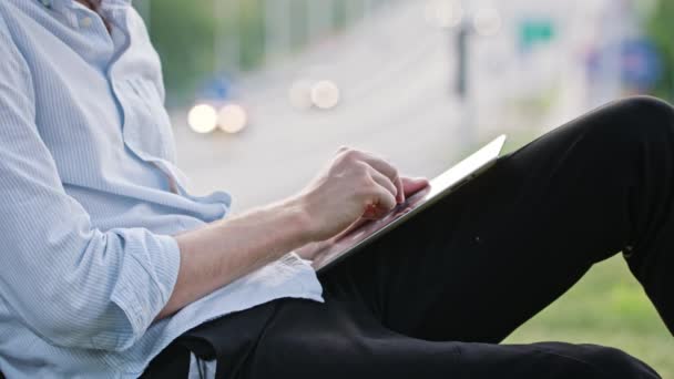 Un joven usando una tableta al aire libre — Vídeo de stock