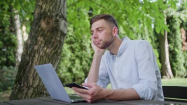 Parkta bir telefonu kullanarak bir genç adam