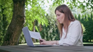 İş kadını parkta bir dizüstü bilgisayar kullanarak