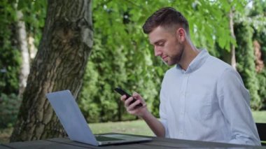 Parkta bir telefonu kullanarak bir genç adam