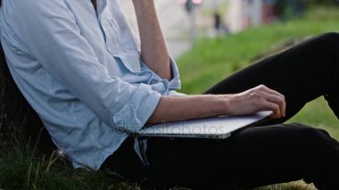 Bir ağacın altında telefonda konuşan bir genç adam