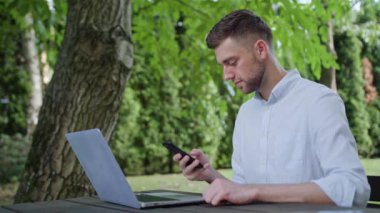 Parkta bir telefonu kullanarak bir genç adam