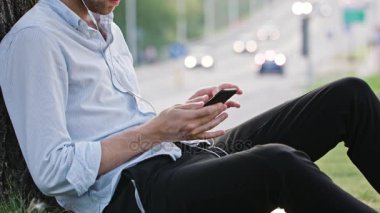 Genç bir adam açık havada bir cep telefonu kullanarak