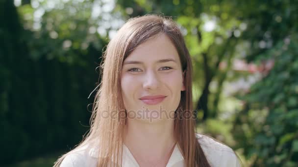 Девушка смотрит в камеру и улыбается — стоковое видео