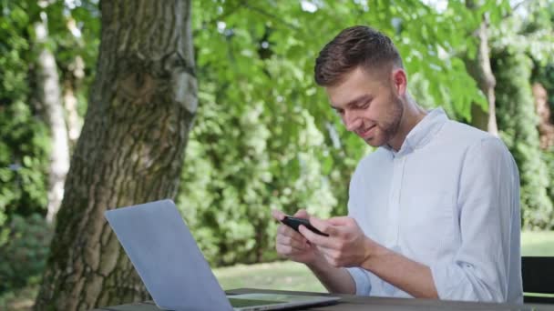 En ung Man som spelar spel på telefonen — Stockvideo