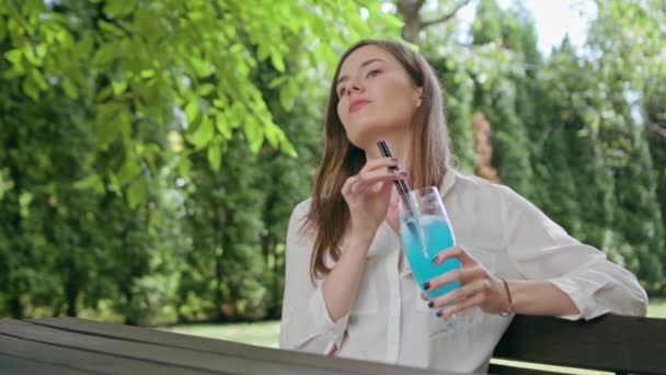 Lady bebiendo batido en el parque — Vídeos de Stock