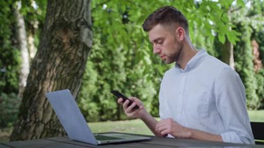 Parkta bir telefonu kullanarak bir genç adam