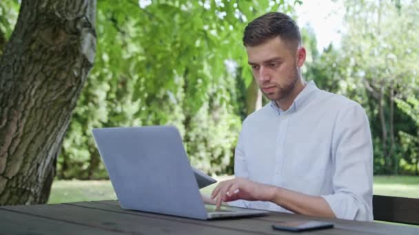 Een jonge Man met een Laptop en een Tablet — Stockvideo