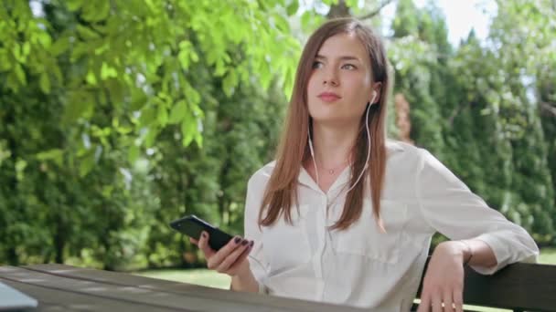 Lady i parken Lyssna på musik på telefonen — Stockvideo