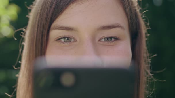 Jeune femme dans le parc utilisant un téléphone — Video