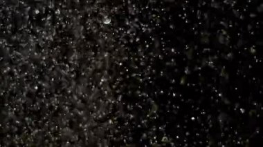 Siyah arka plan üzerinde patlayan gerçekçi Glitter.