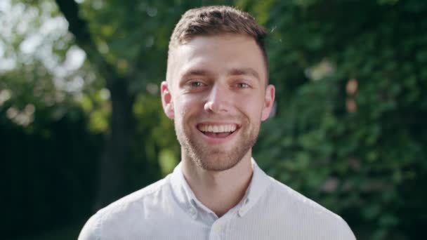 Jeune homme regardant la caméra et souriant — Video