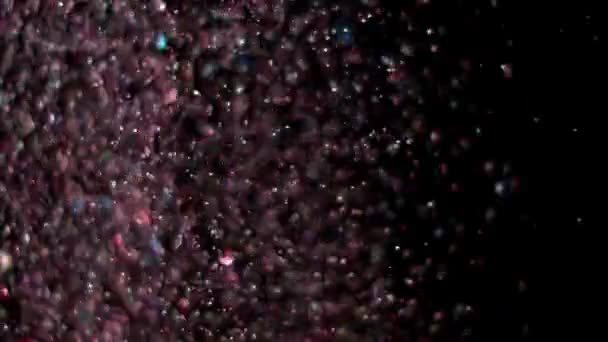 Paillettes réalistes explosant sur fond noir .