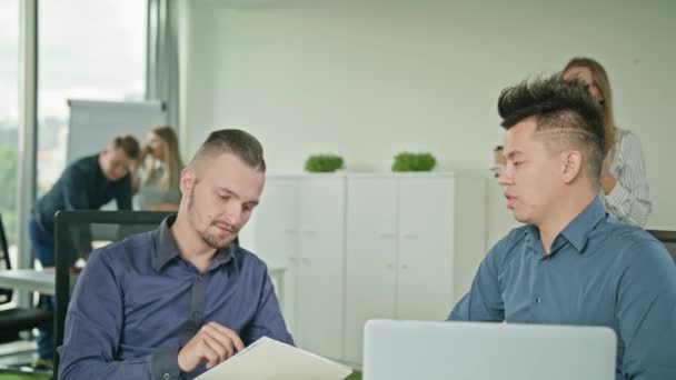 Два человека работают над ноутбуком — стоковое видео