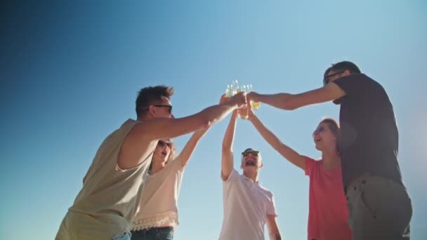 A fiatalok csengő palackok a strandon — Stock videók